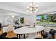 Open-concept living room and dining area featuring hardwood floors, designer lighting, and large picture windows at 3666 S Jersey St, Denver, CO 80237