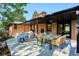 Covered patio with outdoor seating and dining area featuring brick exterior and green backyard at 3666 S Jersey St, Denver, CO 80237