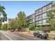 Modern apartment building featuring large windows and mature landscaping on a tree-lined street at 1050 N Corona St # 105, Denver, CO 80218