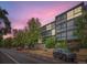 Modern apartment building with large windows and mature trees creating an inviting street view at 1050 N Corona St # 105, Denver, CO 80218