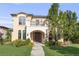 Elegant stucco home featuring manicured lawn, stone archway, second story balcony and lush landscaping at 2362 Spruce Way, Denver, CO 80238