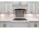 Elegant kitchen with a decorative backsplash, stainless steel appliances, and white cabinetry at 2362 Spruce Way, Denver, CO 80238