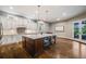 Bright kitchen with a large island with seating, pendant lighting, and white cabinetry at 2362 Spruce Way, Denver, CO 80238