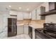 Functional kitchen with white cabinets, black appliances, and updated fixtures at 63 S Sable Blvd # E22, Aurora, CO 80012