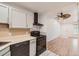 The kitchen opens into the living room, featuring white cabinets and black appliances at 63 S Sable Blvd # E22, Aurora, CO 80012