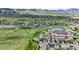 This is an aerial view of houses in a neighborhood with paths, green fields, and mountains in the background at 9721 Marmot Ridge Cir, Littleton, CO 80125