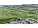 This is an aerial view of homes in a neighborhood with paths, green fields, and mountains in the background at 9721 Marmot Ridge Cir, Littleton, CO 80125