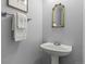 The half bathroom features a pedestal sink, a decorative mirror, and neutral-colored walls at 9721 Marmot Ridge Cir, Littleton, CO 80125