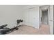 This carpeted work out room has a weight set and an elliptical near a closet and doorway at 9721 Marmot Ridge Cir, Littleton, CO 80125