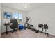 This carpeted workout room has an elliptical, weights, ceiling fan, desk, and window with a view at 9721 Marmot Ridge Cir, Littleton, CO 80125