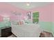 Pastel bedroom features soft lighting, charming wall decor, and bright window views at 9721 Marmot Ridge Cir, Littleton, CO 80125