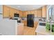 A bright kitchen features wood cabinets, recessed lighting, and modern appliances, including a black refrigerator at 9721 Marmot Ridge Cir, Littleton, CO 80125