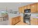 An open-concept kitchen features wood cabinets and stainless steel appliances, with a view of the dining room at 9721 Marmot Ridge Cir, Littleton, CO 80125
