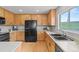 Bright kitchen featuring wooden cabinets, light countertops, and a stainless steel sink at 9721 Marmot Ridge Cir, Littleton, CO 80125
