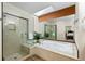 Relaxing bathroom features a soaking tub, shower, skylight and large mirror at 1901 S Union Pl, Lakewood, CO 80228