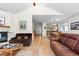 Open-concept living room featuring a fireplace, hardwood floors, and a view into the kitchen at 1901 S Union Pl, Lakewood, CO 80228