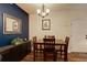 Cozy dining room with wood table and seating for four, dark accent wall and modern light fixture at 2430 W 82Nd Pl # 2F, Westminster, CO 80031