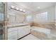 Bright bathroom featuring marble countertops, built-in tub, and glass block window at 2770 S Elmira St # 2, Denver, CO 80231