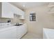 Bright laundry room has washer, dryer, sink, and ample white cabinets at 2770 S Elmira St # 2, Denver, CO 80231