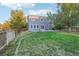 Large backyard with a two-story home, wooden fence, and green grass at 5109 S Malta Way, Centennial, CO 80015