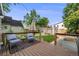 Back deck with outdoor seating and an umbrella overlooks the landscaped yard with pergola and planting beds at 3881 Zenobia St, Denver, CO 80212