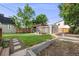 Landscaped backyard featuring a pergola with outdoor seating, a garden area, and a well-maintained lawn at 3881 Zenobia St, Denver, CO 80212