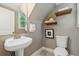 Cozy bathroom features modern fixtures, a pedestal sink, and decorative wooden shelving at 3881 Zenobia St, Denver, CO 80212
