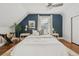 Bright bedroom featuring a ceiling fan, natural light, an accent wall, and hardwood floors with decorative rug at 3881 Zenobia St, Denver, CO 80212