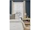 Well-lit bedroom featuring white bedding, a nightstand with stylish lamp and window with natural light at 3881 Zenobia St, Denver, CO 80212