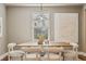 Sunlit dining room features a wooden table, unique pendant light, and minimalist wall art at 3881 Zenobia St, Denver, CO 80212