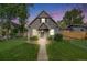 Charming gray home with a well-manicured lawn and lovely landscaping under a beautiful colorful sunset sky at 3881 Zenobia St, Denver, CO 80212