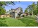 Charming gray two-story home with a well-manicured lawn and beautiful mature trees on a sunny day at 3881 Zenobia St, Denver, CO 80212