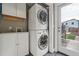 A laundry room featuring a stacked washer and dryer with ample storage and access to the outdoors at 3881 Zenobia St, Denver, CO 80212