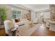 Spacious living room with modern furnishings, hardwood floors, and ample natural light into the dining area at 3881 Zenobia St, Denver, CO 80212