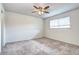 This bedroom features neutral carpet, a ceiling fan, and a window to provide ample light at 7260 S Gaylord St # E26, Littleton, CO 80122