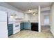 Well-lit kitchen with white and blue cabinets and black appliances at 7260 S Gaylord St # E26, Littleton, CO 80122