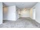 Bright living room with white walls and light carpet, with adjacent kitchen space at 7260 S Gaylord St # E26, Littleton, CO 80122