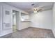 Cozy living room showcasing open kitchen view, neutral walls, and plush carpet at 7260 S Gaylord St # E26, Littleton, CO 80122