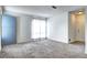 Bright living room features neutral carpet, a large window, and a blue door at 7260 S Gaylord St # E26, Littleton, CO 80122