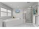 Luxurious bathroom with a soaking tub, separate shower, and stylish marble tile throughout at 3041 Starling Ct, Castle Rock, CO 80109