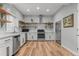 Modern kitchen with stainless steel appliances, white cabinets, hardwood floors, and butcher block shelves at 3041 Starling Ct, Castle Rock, CO 80109