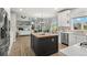 Modern kitchen with stainless steel appliances, white cabinetry, wooden island, and views of the living area at 3041 Starling Ct, Castle Rock, CO 80109