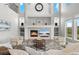 Bright, modern living room with fireplace, television, and high ceilings with views of the lush lawns outside at 3041 Starling Ct, Castle Rock, CO 80109