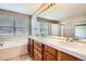 Bathroom featuring a double sink vanity, a soaking tub, and ample lighting at 2561 Cactus Bluff Pl, Highlands Ranch, CO 80129