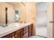 Bathroom featuring double vanity with wood cabinets and a large mirror at 2561 Cactus Bluff Pl, Highlands Ranch, CO 80129