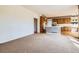 Open-concept living room and kitchen with wood cabinets, updated appliances, and carpet flooring at 2561 Cactus Bluff Pl, Highlands Ranch, CO 80129