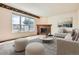 Comfortable living room with brick fireplace, large windows, and neutral decor at 2561 Cactus Bluff Pl, Highlands Ranch, CO 80129