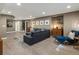 Spacious finished basement with stylish seating, modern lighting, and wood-look flooring at 8915 W Quarto Pl, Littleton, CO 80128