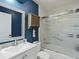 Bathroom boasts blue accent wall, vanity, and shower with glass doors at 8915 W Quarto Pl, Littleton, CO 80128