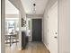 Bright entryway with hardwood floors, stylish lighting, and a view into the dining area at 8915 W Quarto Pl, Littleton, CO 80128